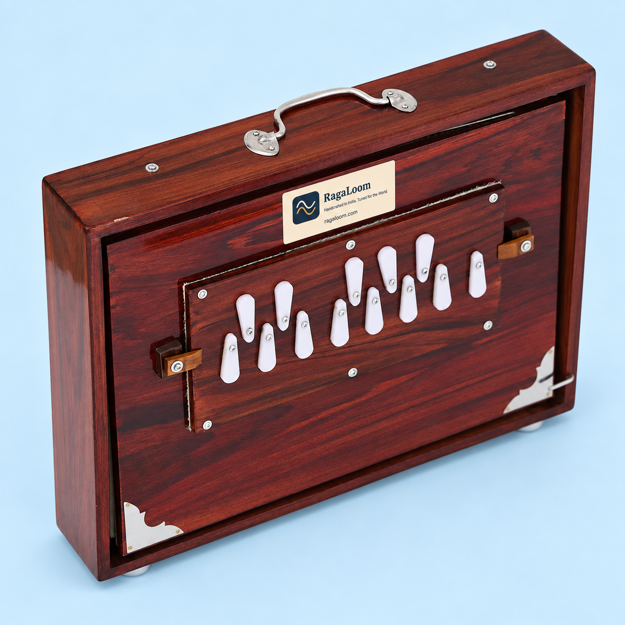 Cherry-finish 16-inch shruti box, closed angled view on pale blue background