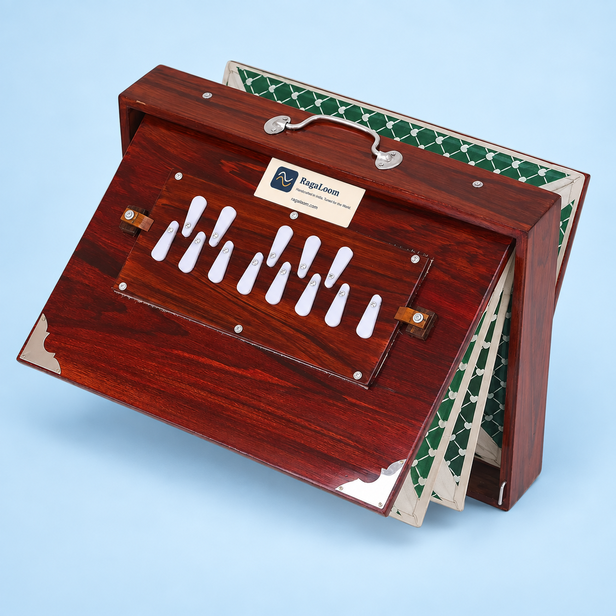 Cherry-finish shruti box with green patterned bellows open, right angle on pale blue background
