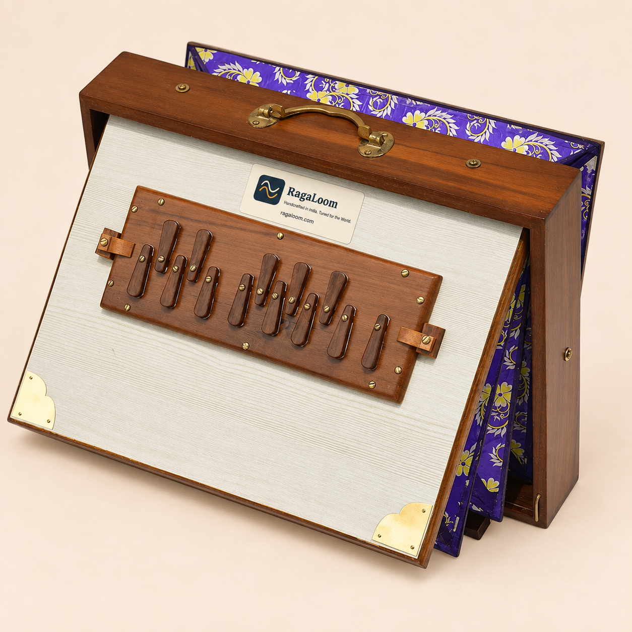 White floral teak shruti box with purple floral bellows open, front angle on pale peach background