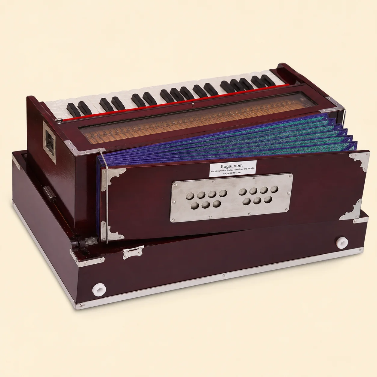 RagaLoom no-stop folding Traveler harmonium with purple and green bellows open