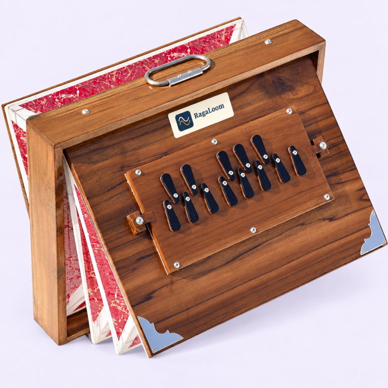 16-inch natural teak shruti box with red patterned bellows open, front angle, RagaLoom label